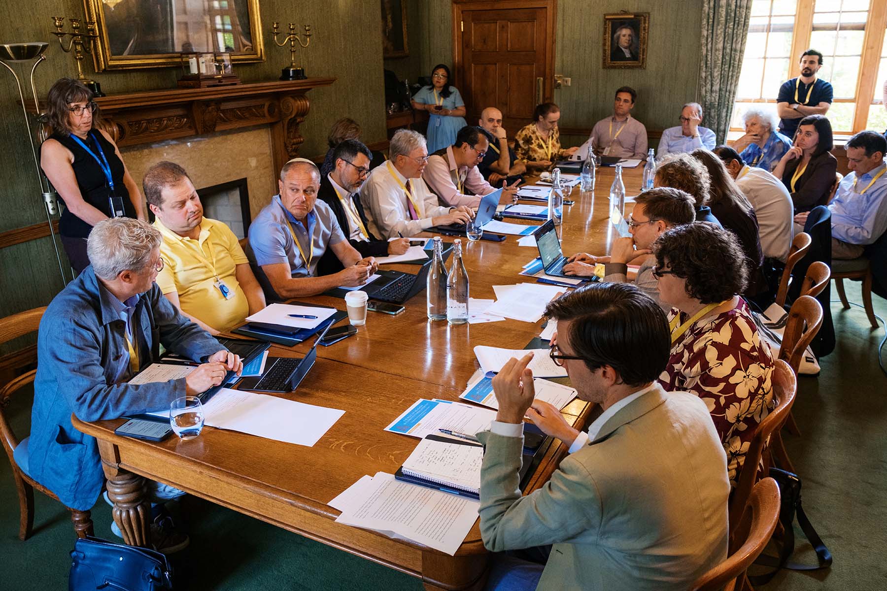Photos of the delegates from Oxford Workshop #1 gathered around the table in discussion.